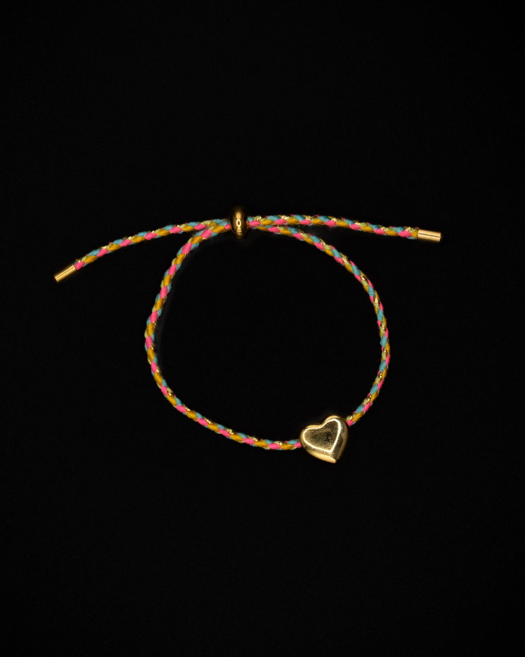 Multicolored braided bracelet with a heart-shaped charm on a black background