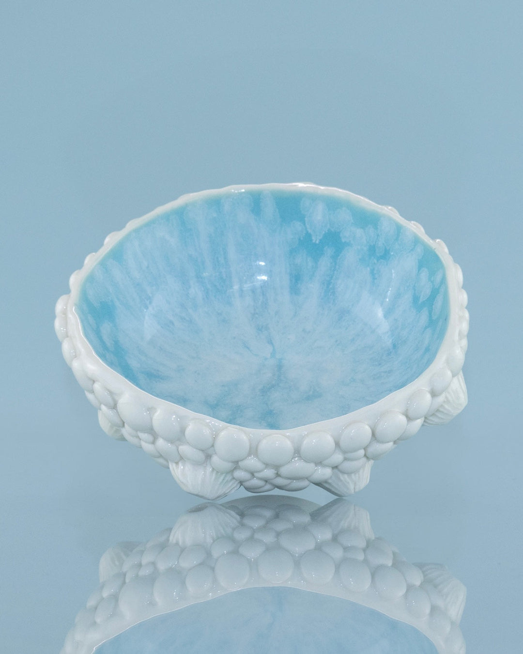 Light blue ceramic bowl with textured surface on a gray background