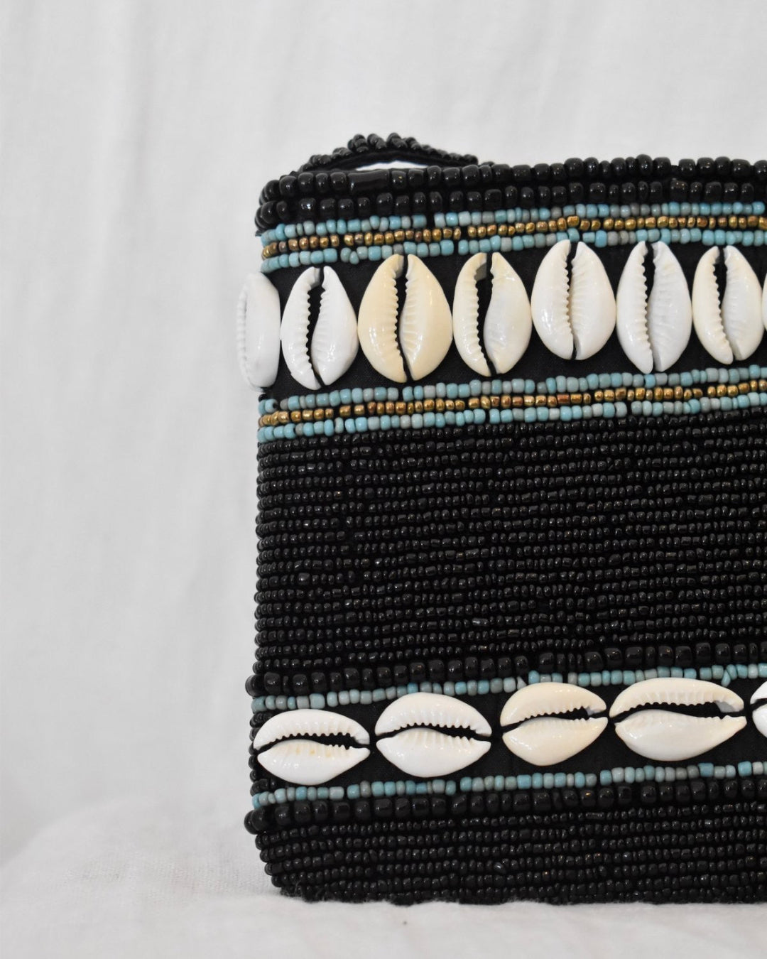 Black beaded pouch with shell decorations on a white background