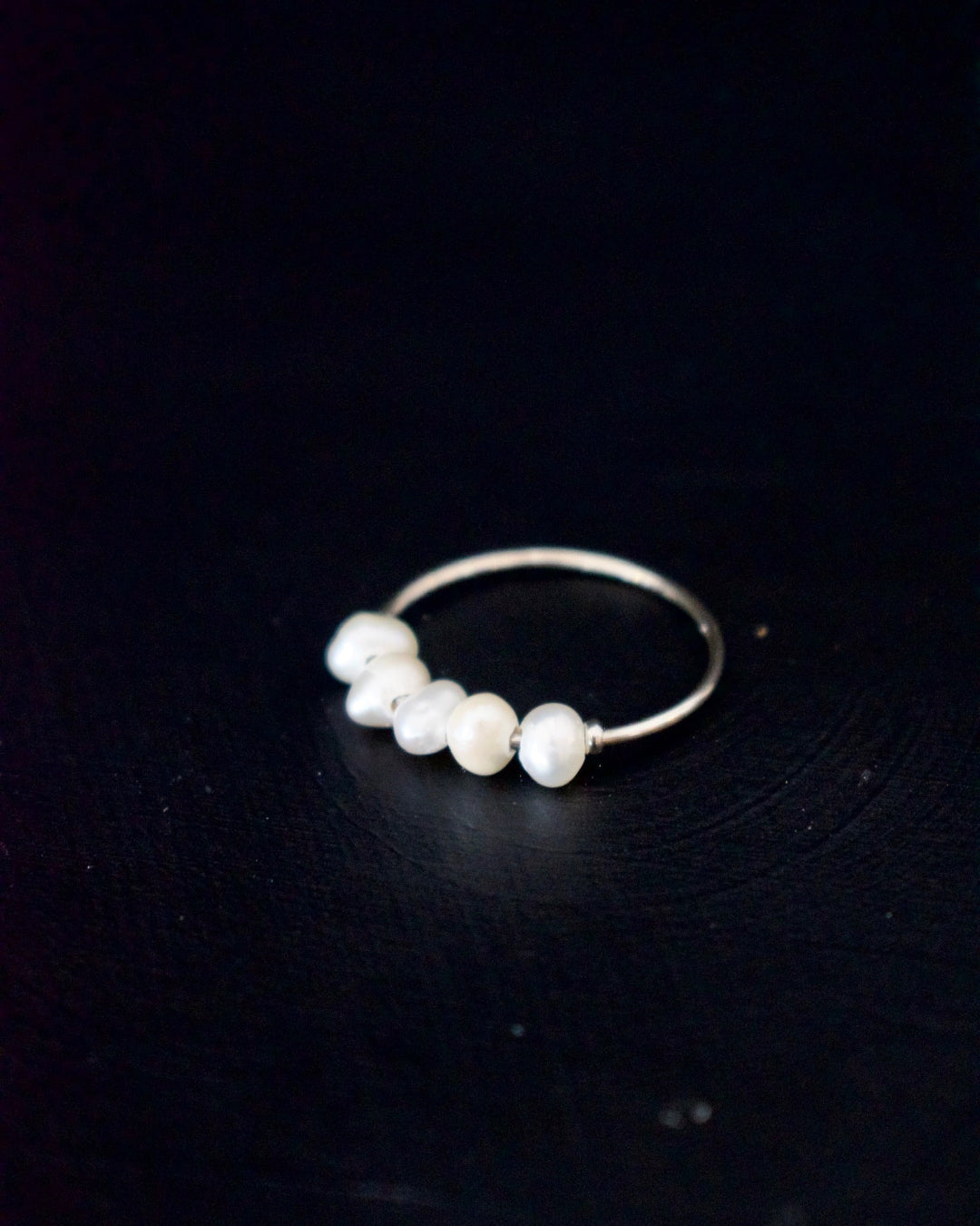 Gold ring with pearls on a dark background