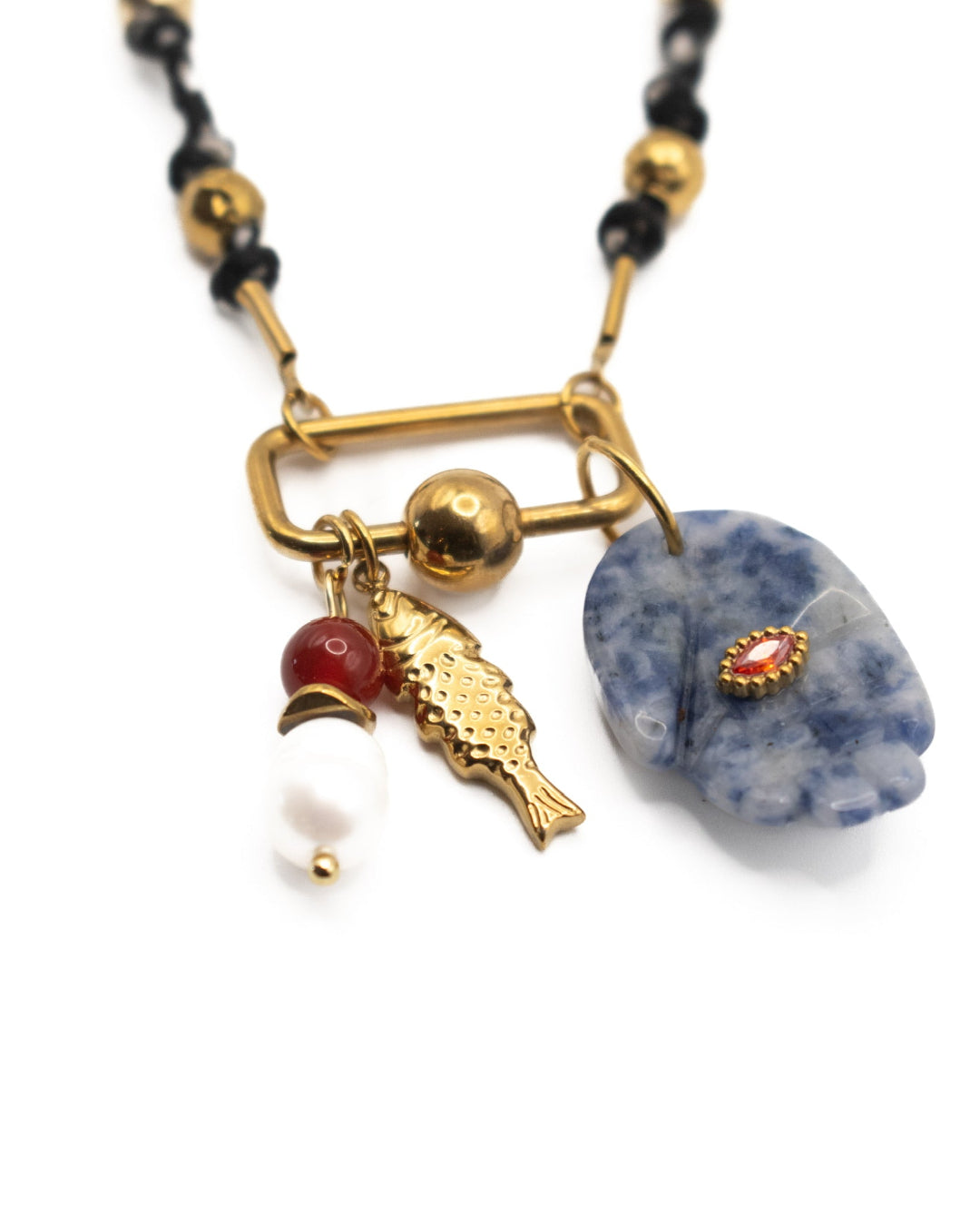 Necklace with gold fish charm, red bead, and blue hand stone on a white background