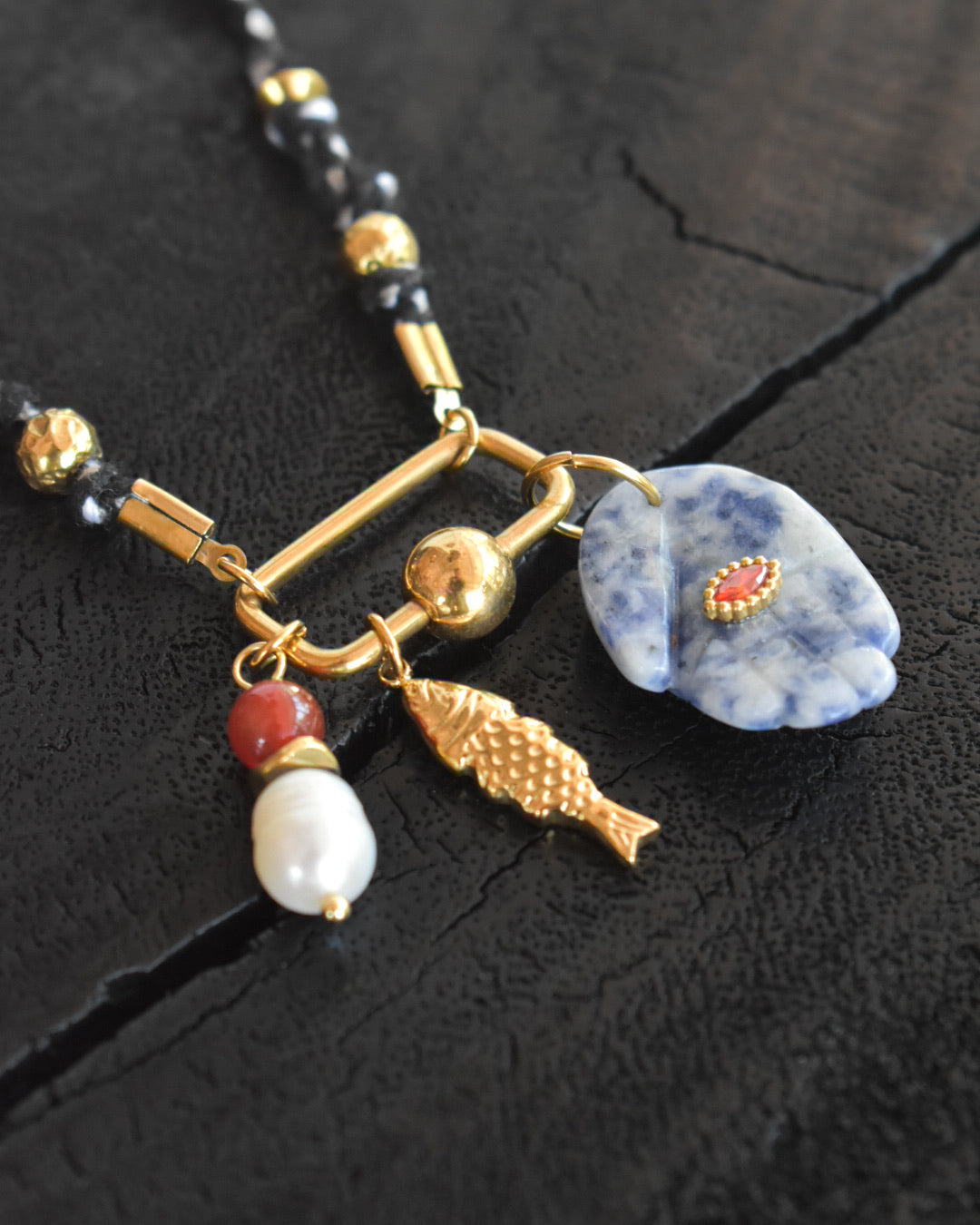 Necklace with various charms on a dark textured surface