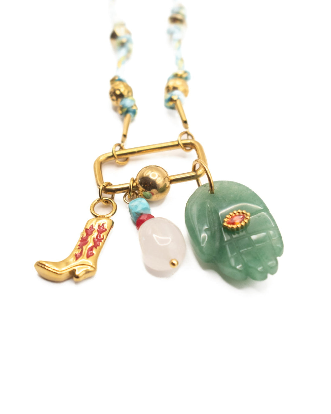 Necklace with various charms including a cowboy boot, pearl, and stone hand on a white background