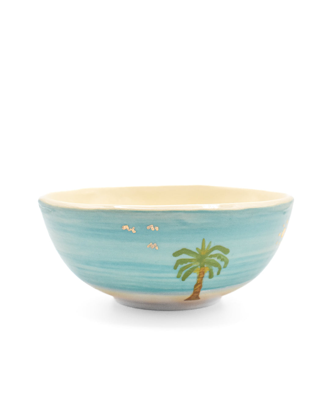 Blue ceramic bowl with palm tree design on a white background