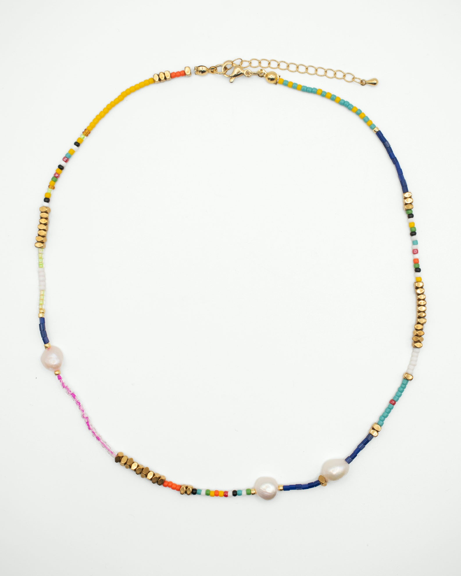 A delicate beaded necklace with gold-tone metal beads, white freshwater pearls, and a multicolor strand featuring yellow, blue, pink, and orange beads, displayed on a clean white background.