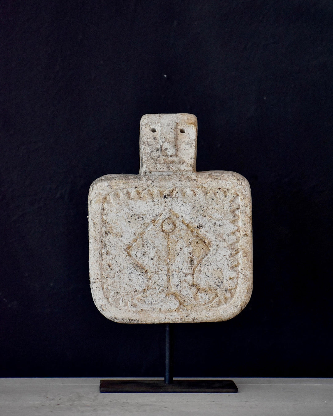 Decorative sandstone statue with a star design on a black background
