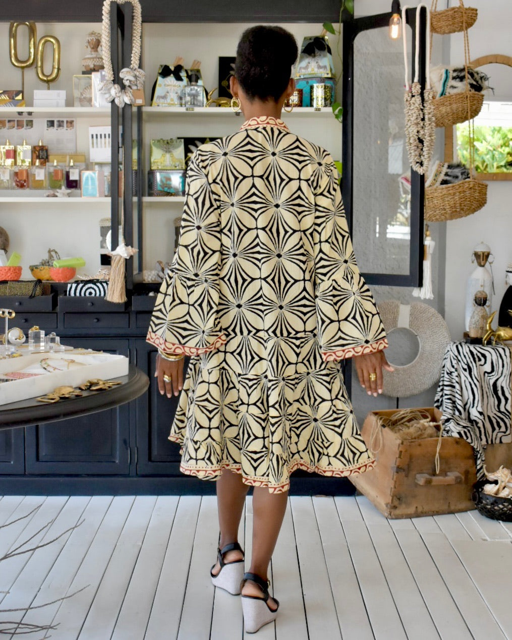 Woman wearing a patterned dress in a stylish interior setting