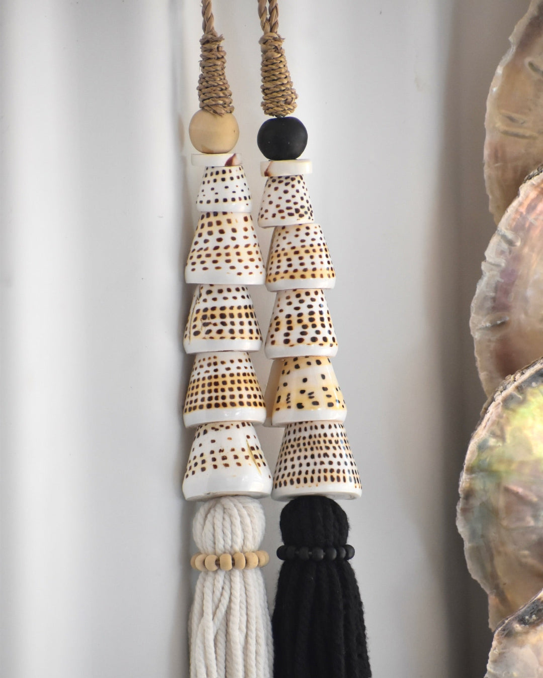Decorative hanging with ceramic beads and tassels on a neutral background