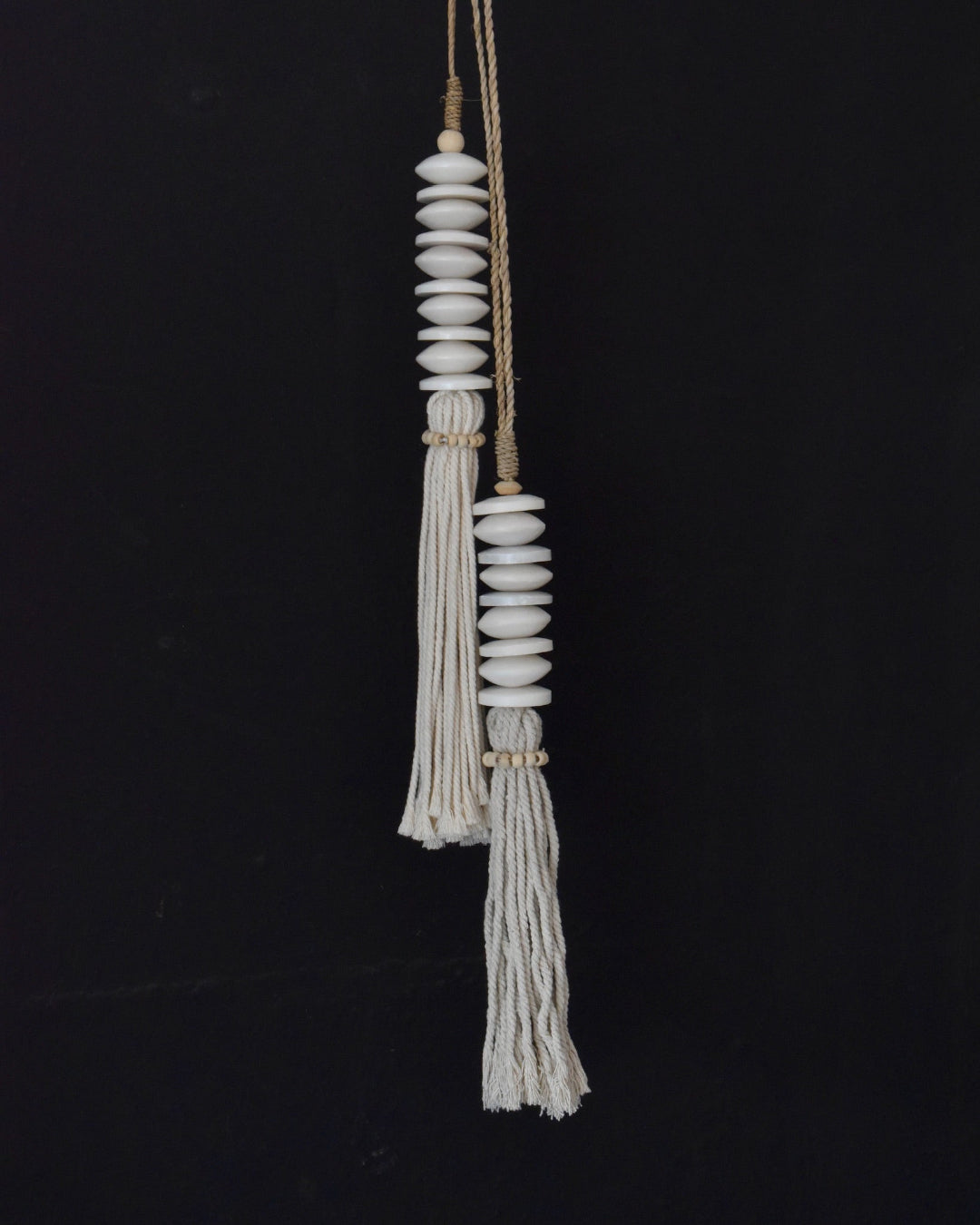 Decorative hanging with beads and tassels on a black background