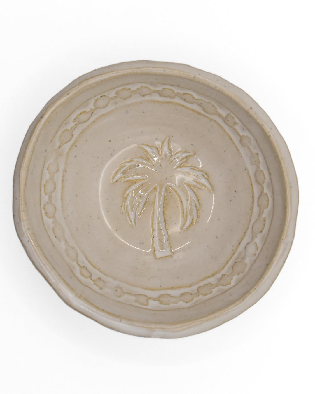 Ceramic bowl with palm tree design on a white background