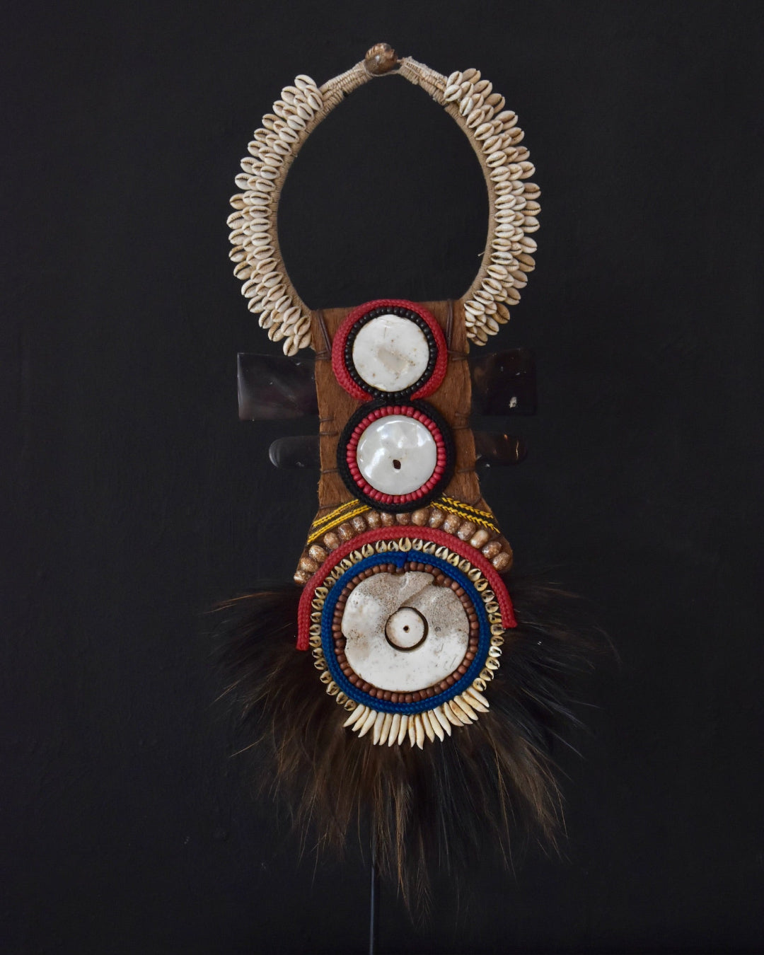 Decorative headpiece with beads and feathers on a black background
