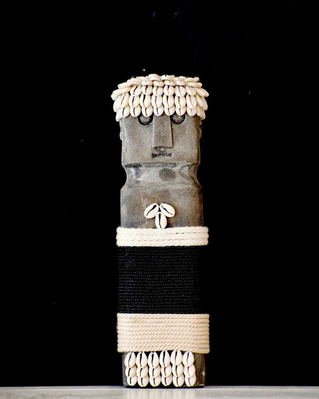 Decorative vase with shell embellishments on a black background