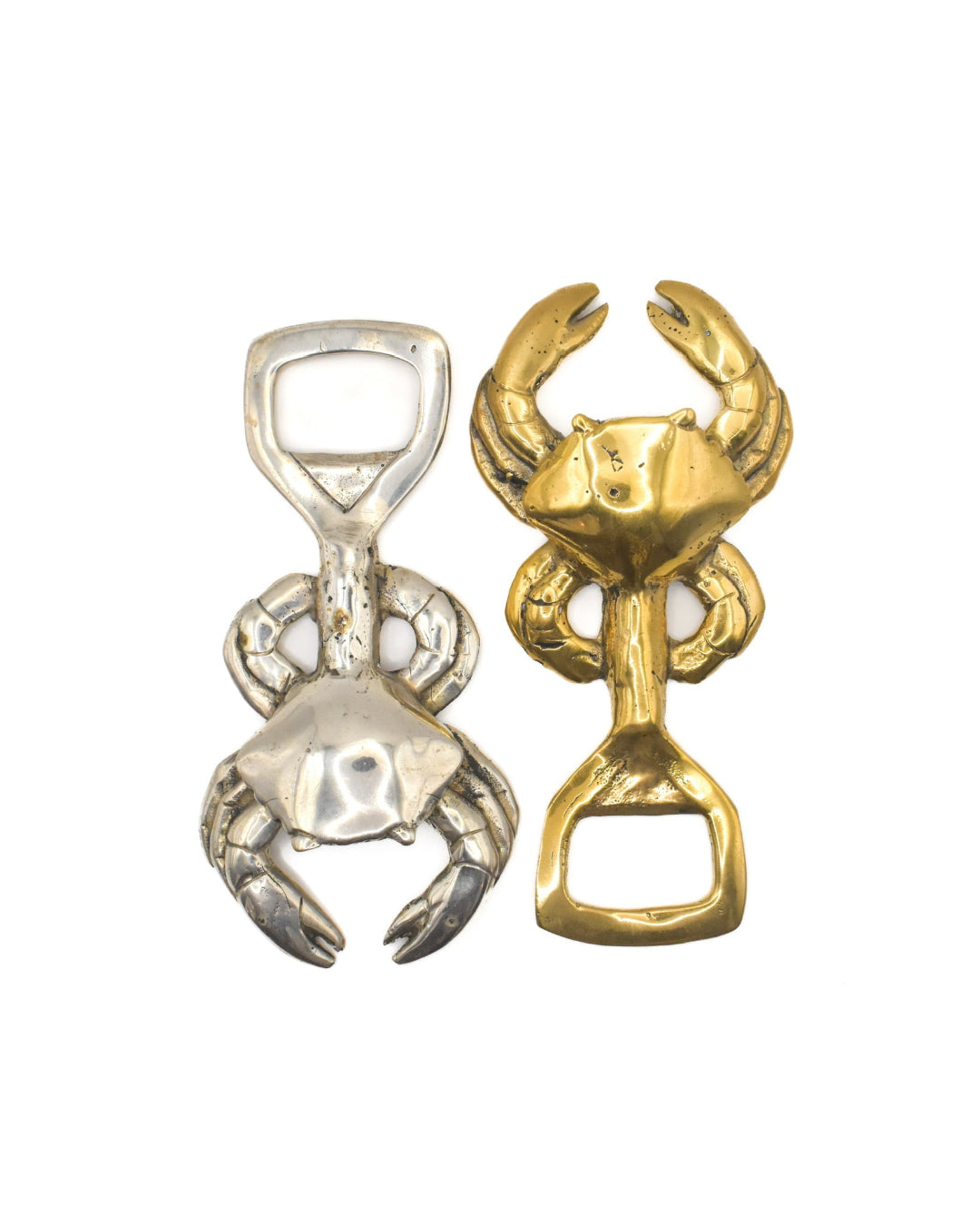 Two crab-shaped bottle openers, one silver and one gold, on a white background.