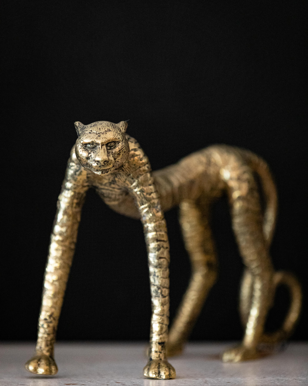 Bronze panther sculpture on a dark background