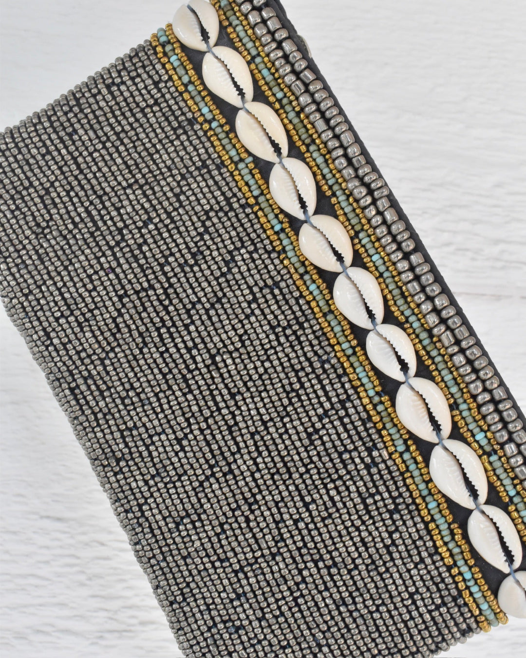 silver beaded clutch and shell pattern on a white background