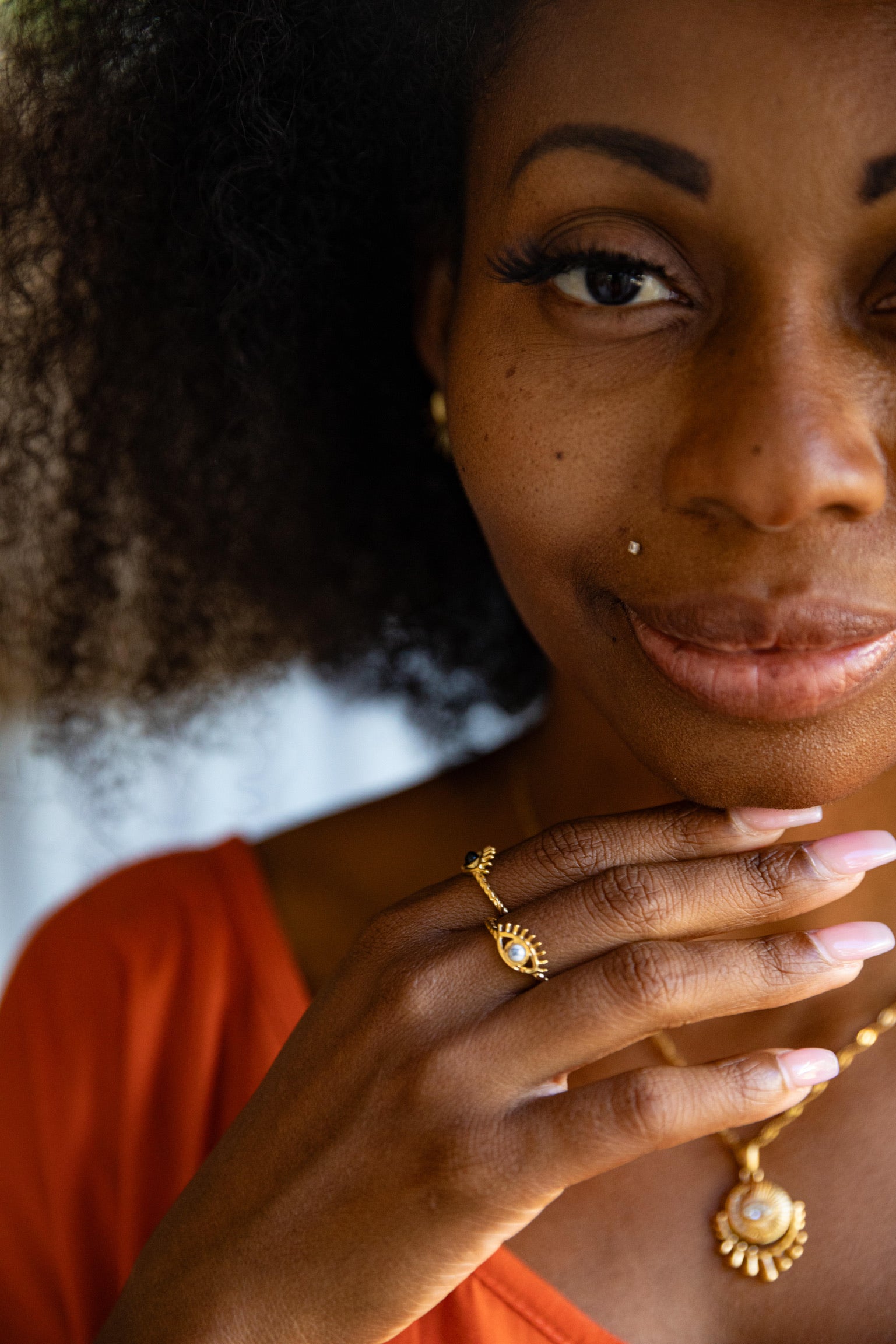 Woman wearing gold jewelry with a blurred background