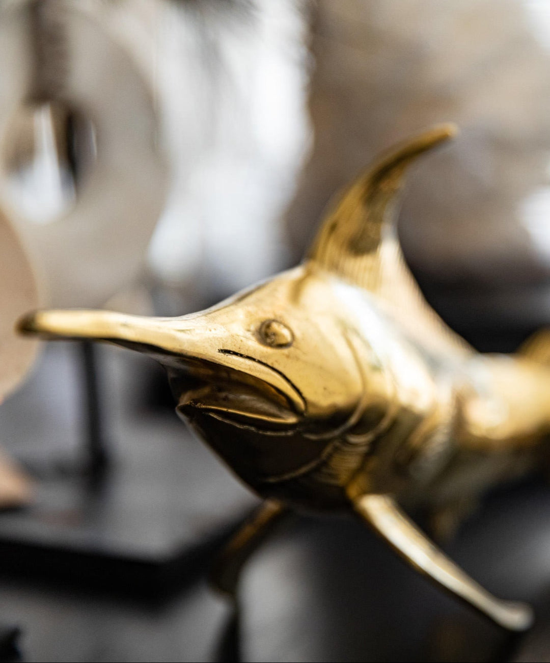 Gold dolphin figurine on a dark surface with a blurred background
