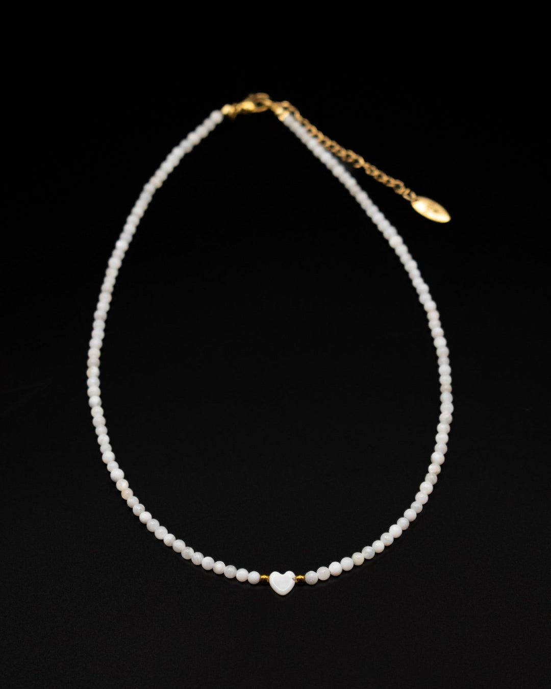 Pearl necklace with a gold clasp on a black background