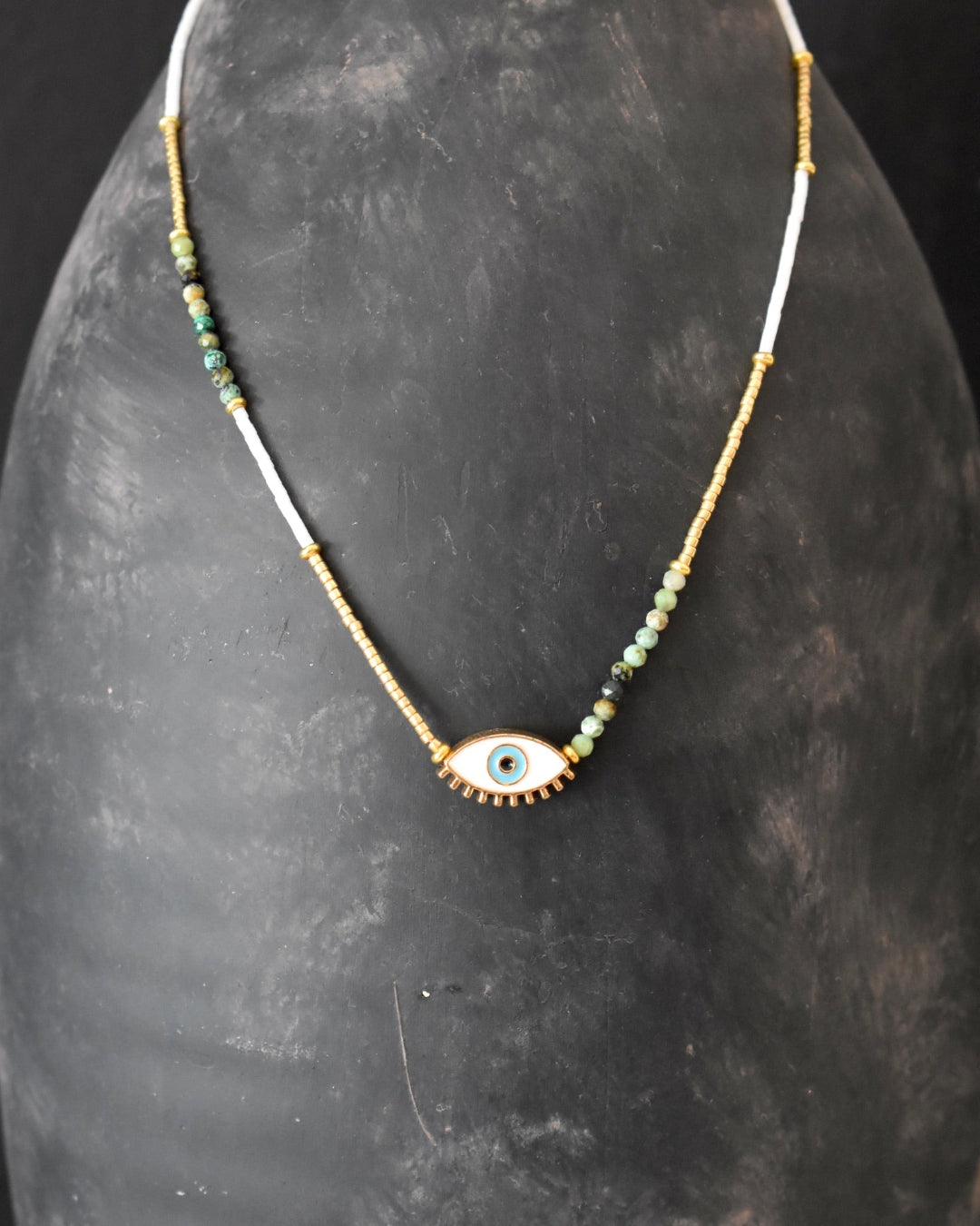 Necklace with an eye-shaped pendant on a dark gray surface