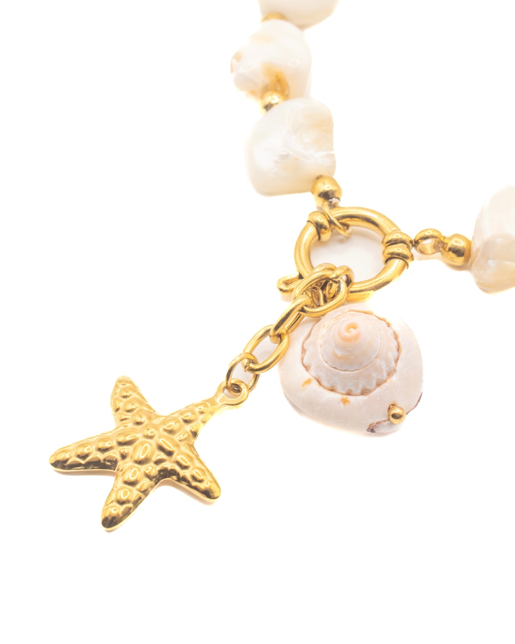 Bracelet with gold starfish and shell charms on a white background