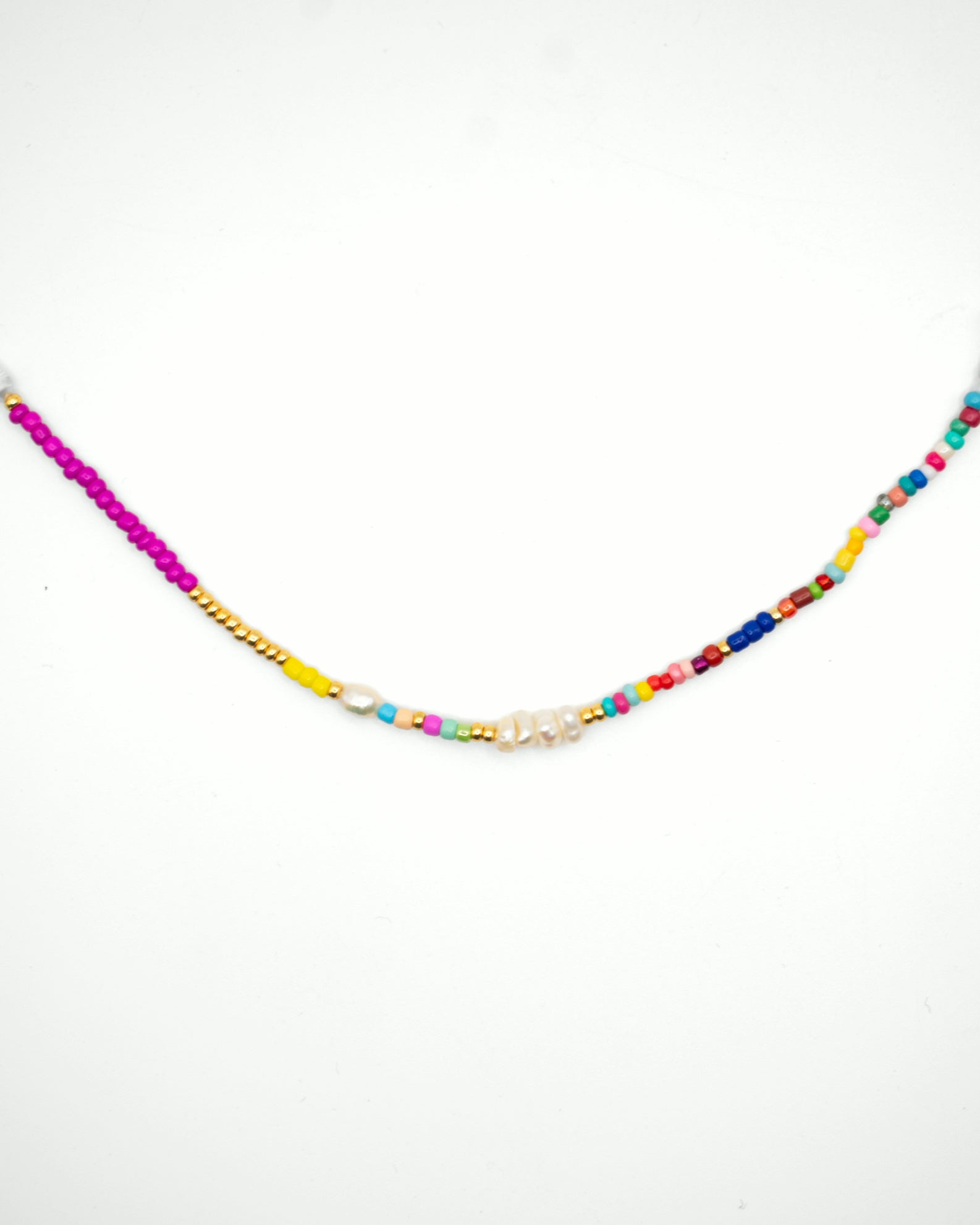 A beaded necklace with a vibrant multicolor design, featuring bright pink, yellow, blue, red, and green beads, with a central cluster of small white pearls on a plain white background.