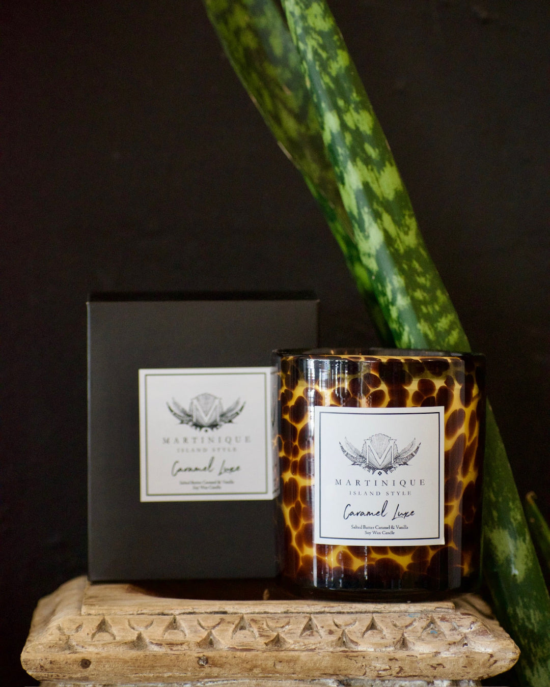 Candle with leopard print design and packaging on a dark background