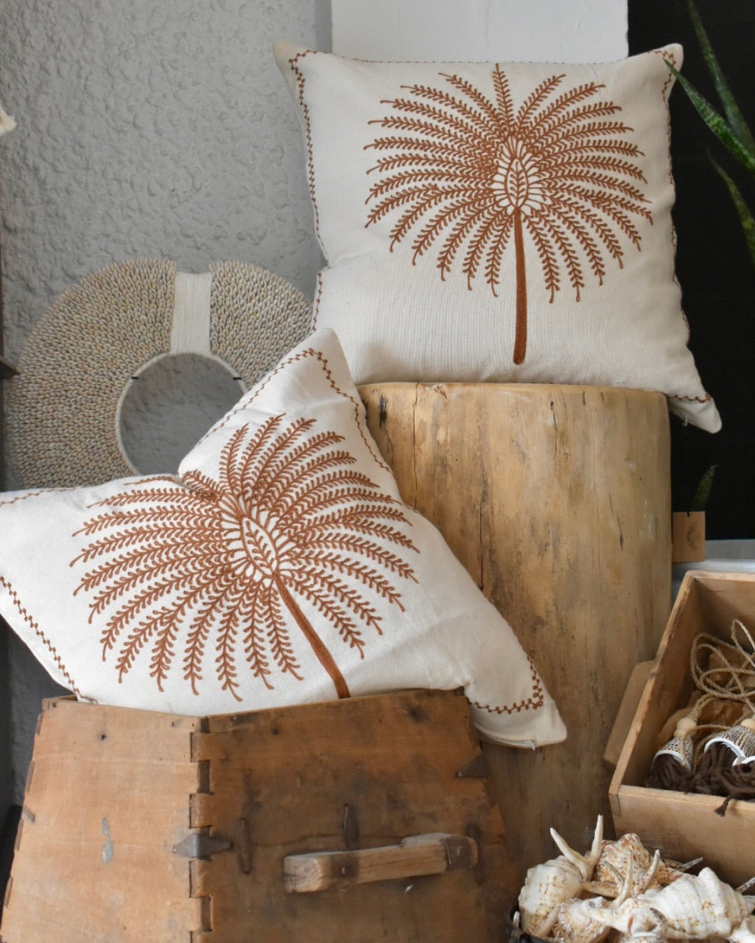 Two decorative pillows with brown patterns on a wooden surface.