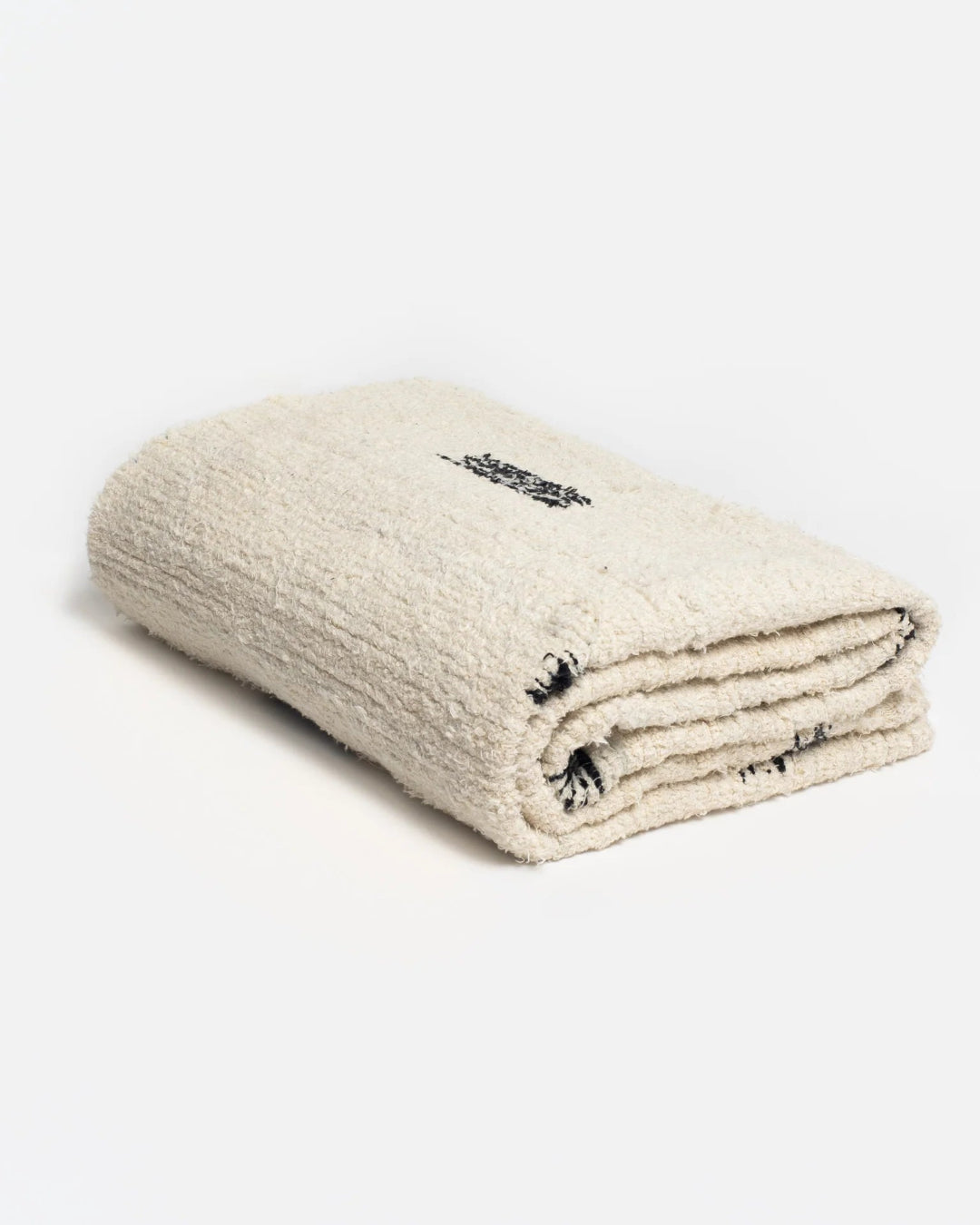 Folded beige blanket with black text on a light gray background