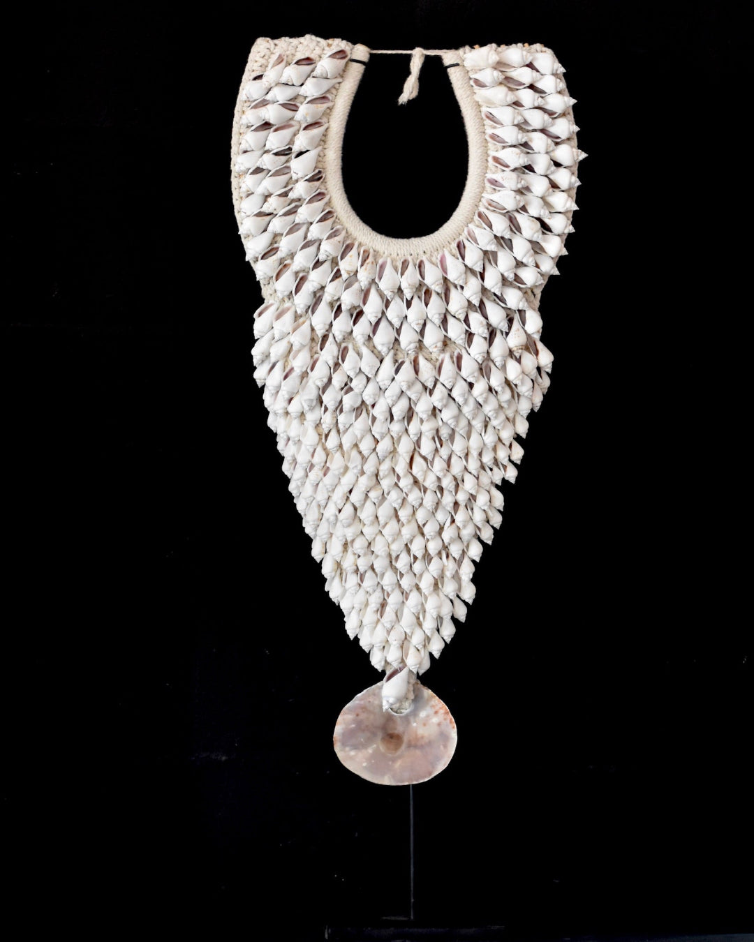 Decorative necklace made of woven material with a central pendant on a black background