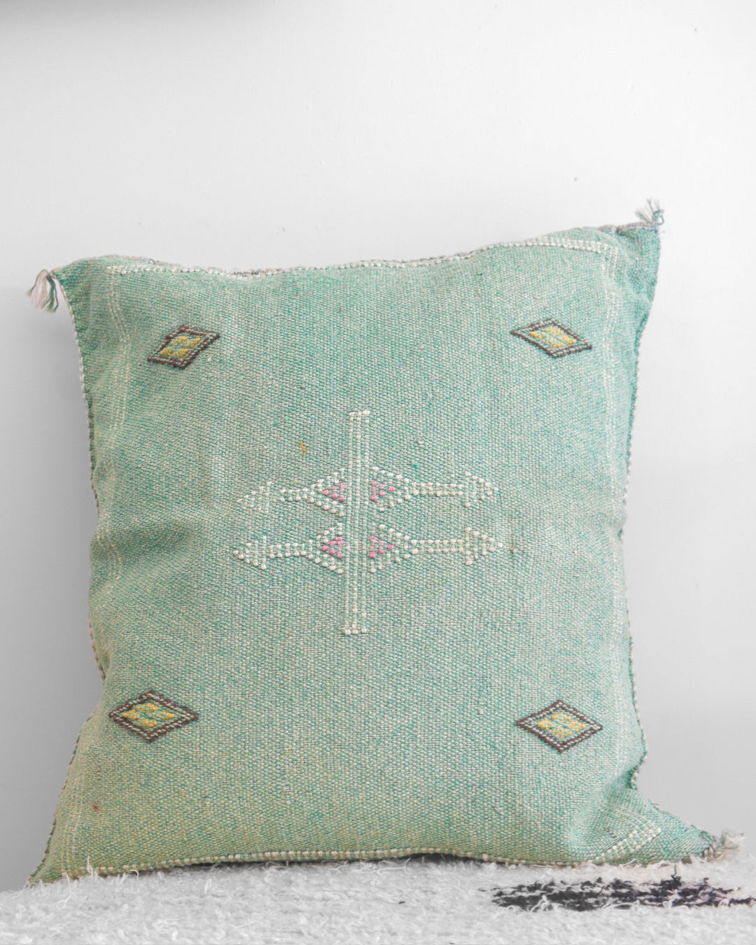 Decorative pillow with geometric patterns on a light gray background