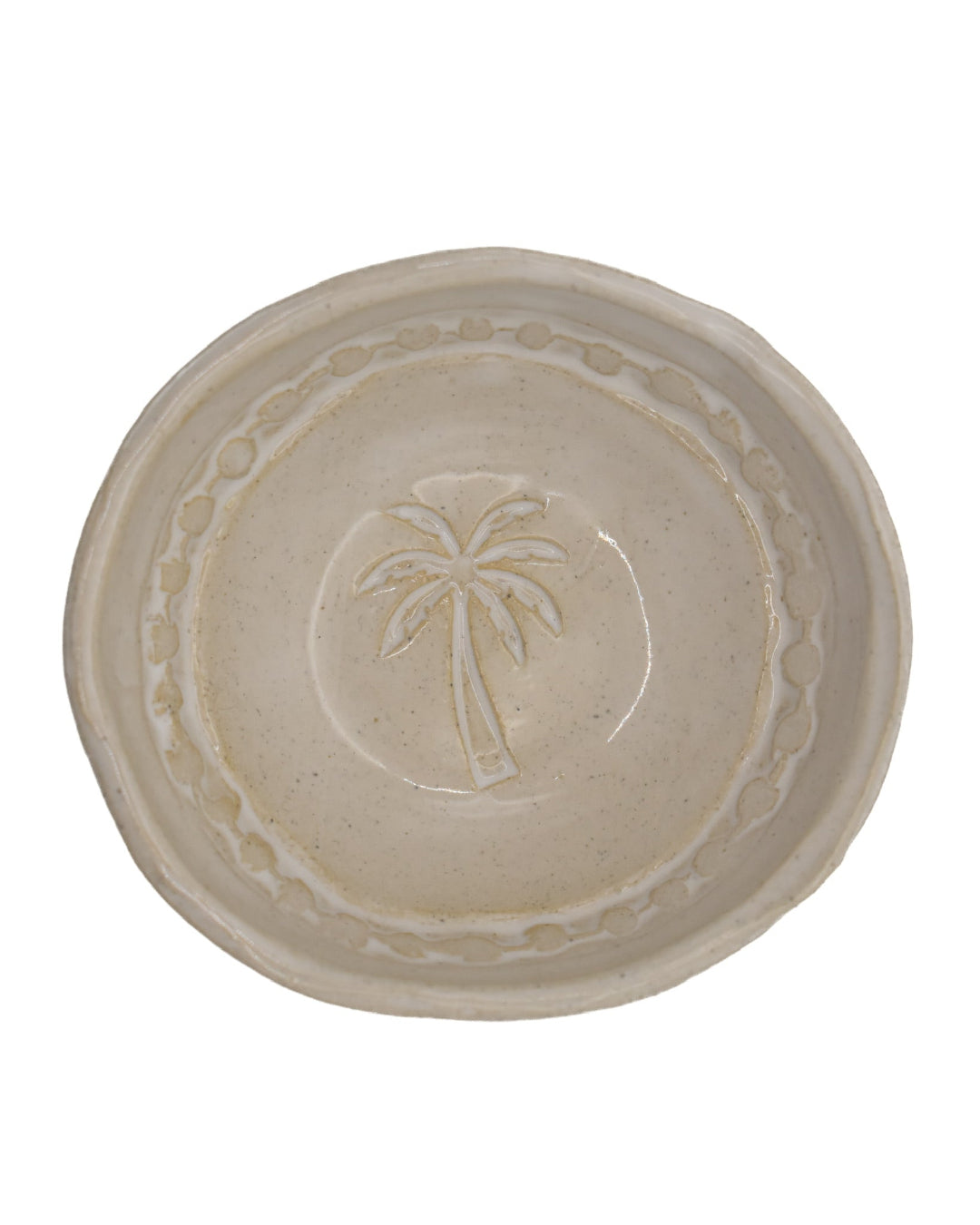 Beige ceramic plate with palm tree design on a white background
