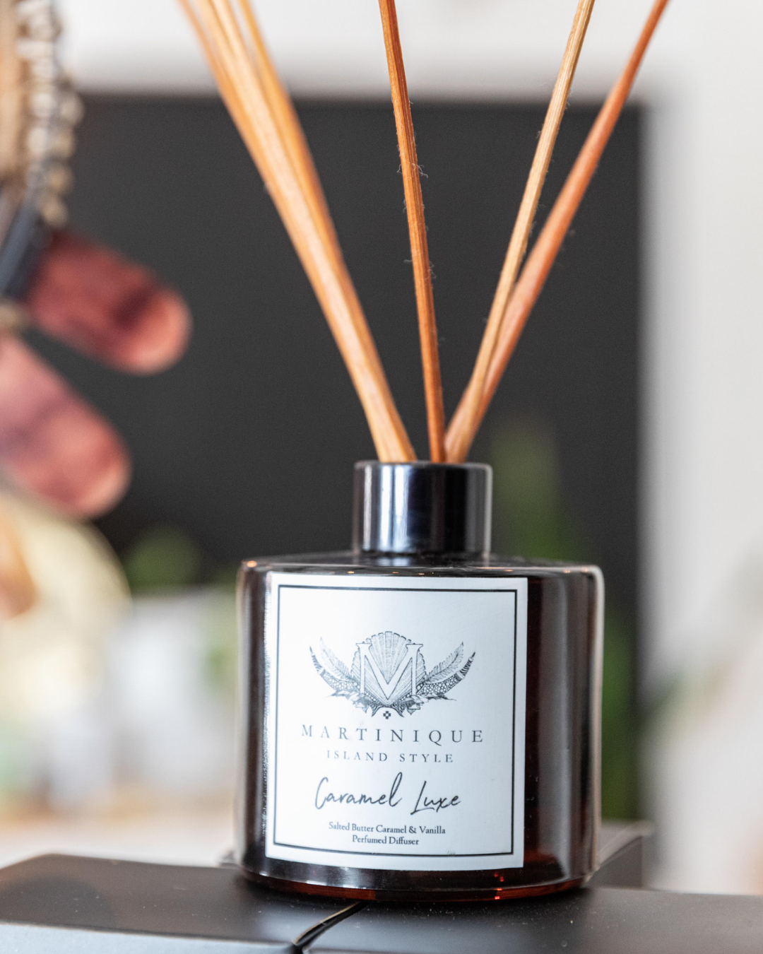 Diffuser with wooden sticks and 'Martinique' label on a blurred background