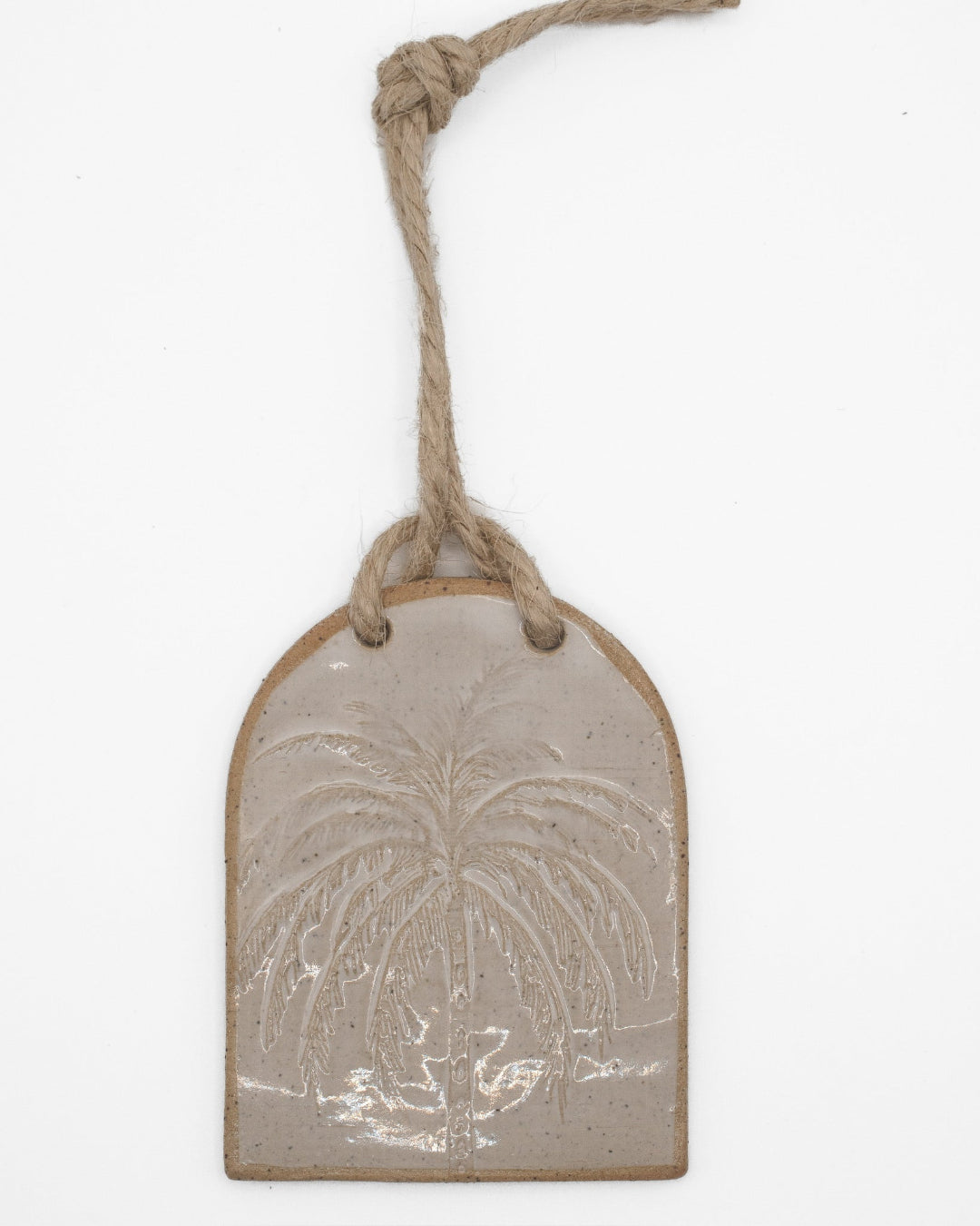 Decorative ceramic tag with palm tree design on a white background