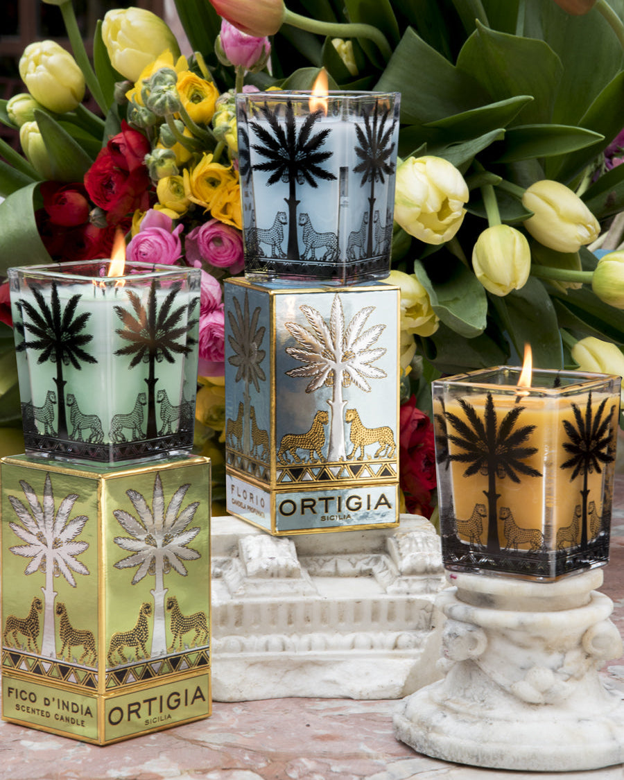 Ortigia candles with decorative boxes and flowers in the background
