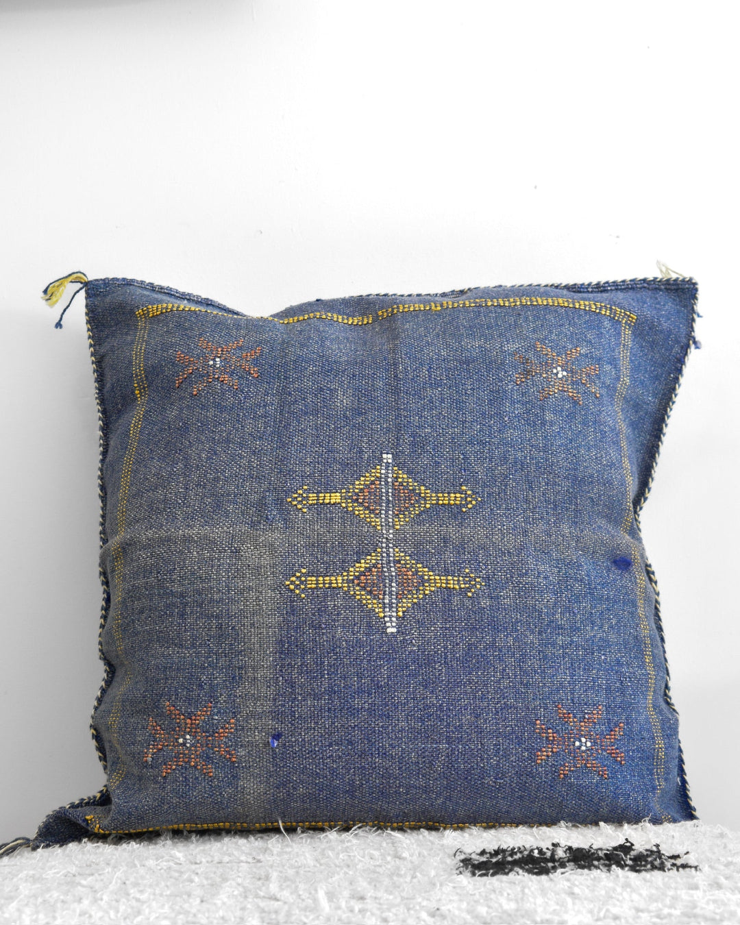 Blue embroidered pillow on a white background