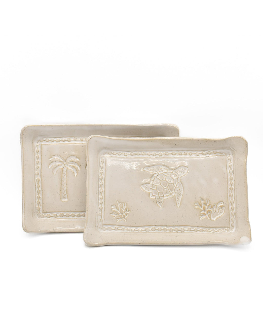Two decorative ceramic trays with embossed designs on a white background