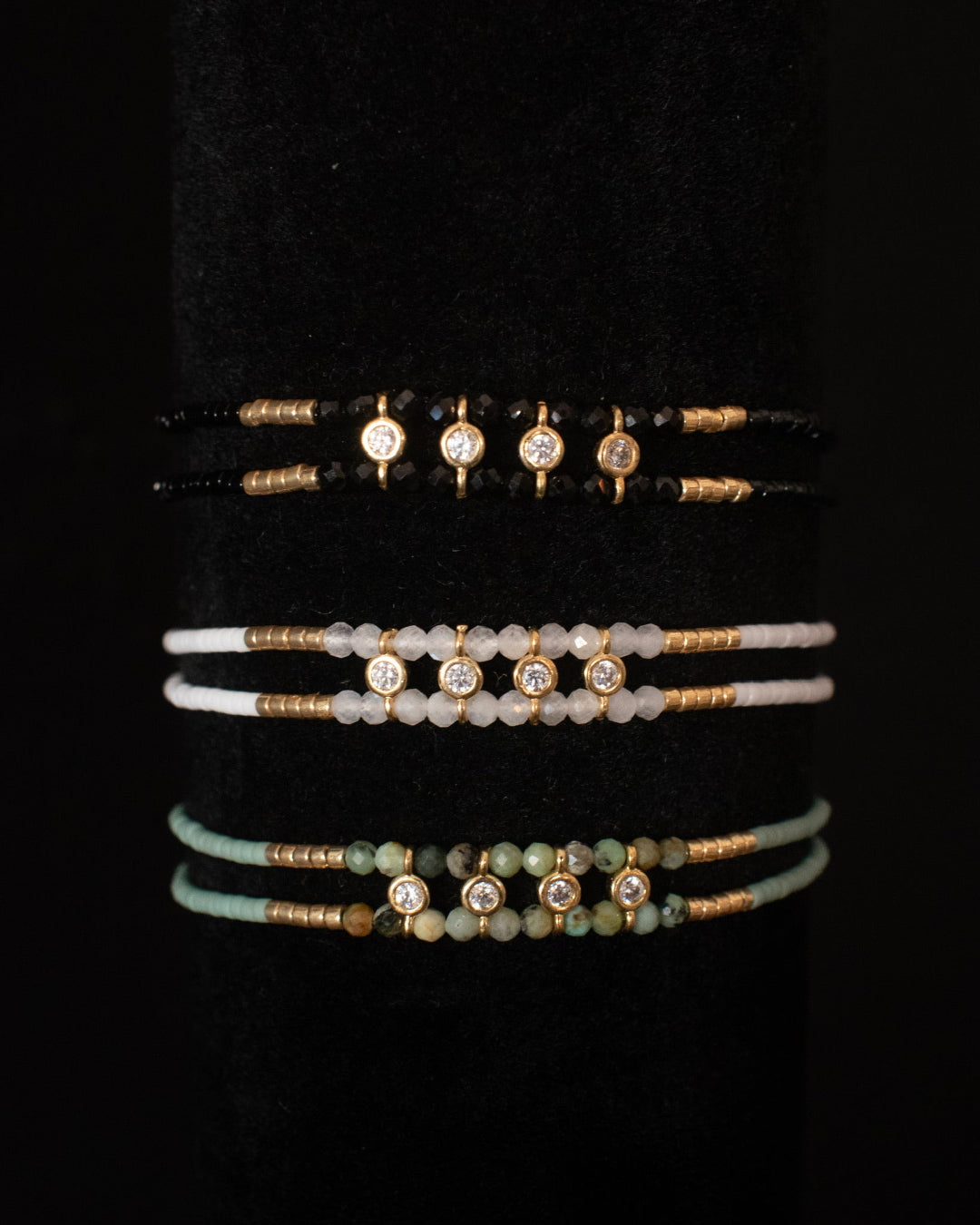 Set of beaded bracelets with gemstones on a black background